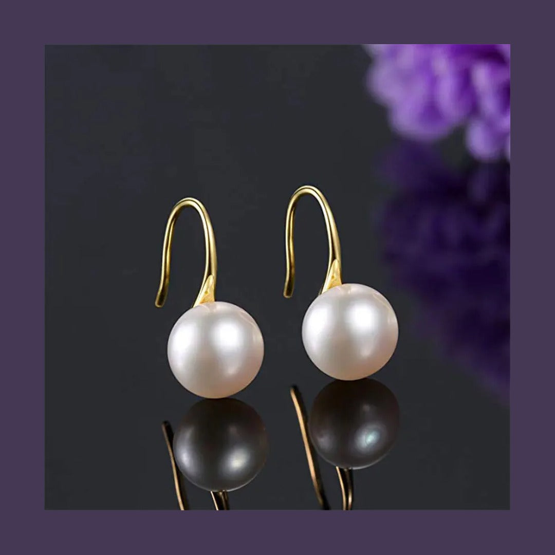 Cultured freshwater pearl drop earrings on dark background